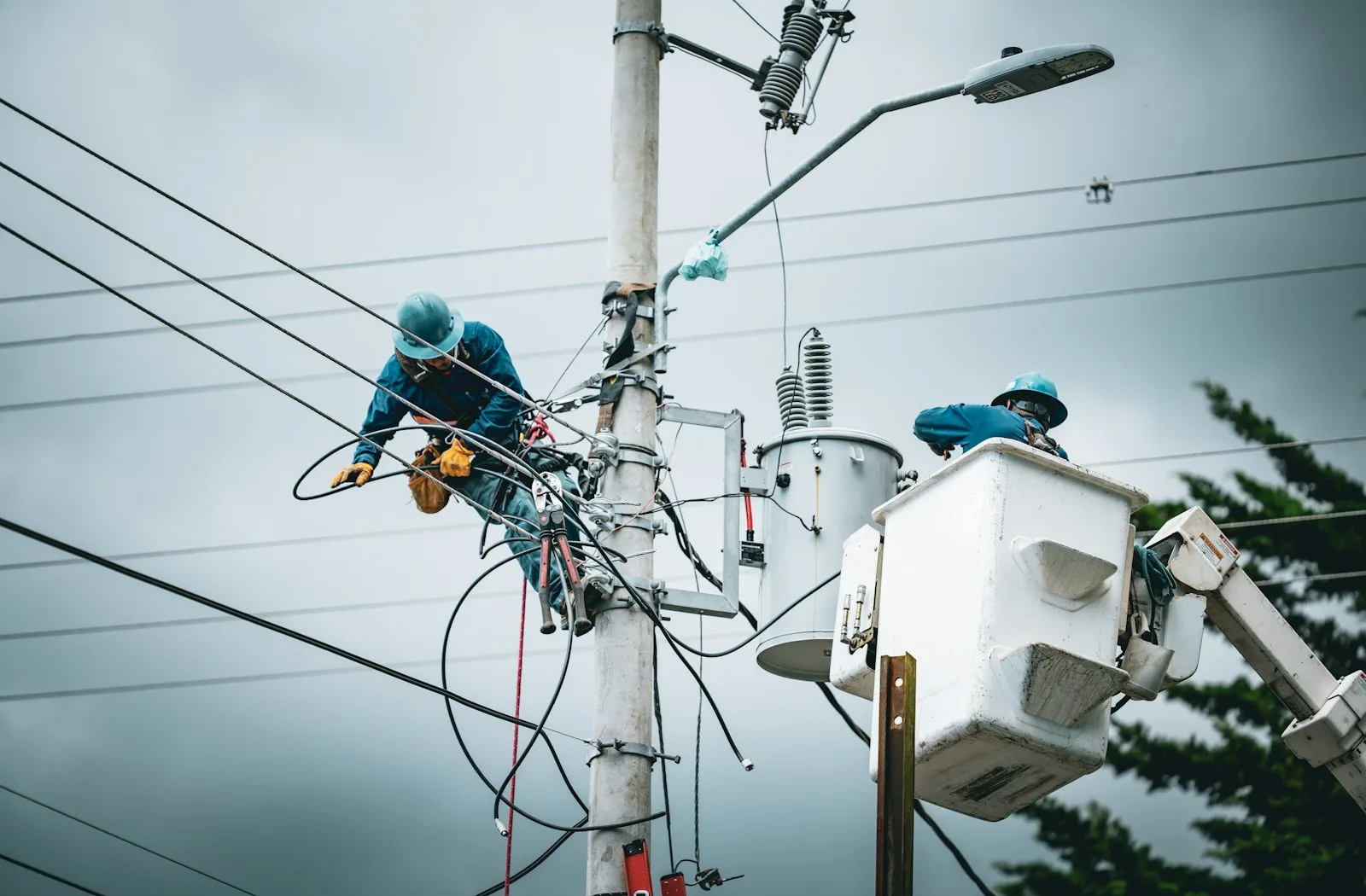 Linemen working from a bucket truck on a utility pole